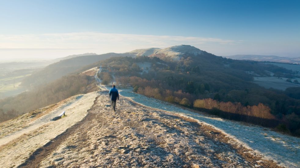 man walking on frosty hill in winter
